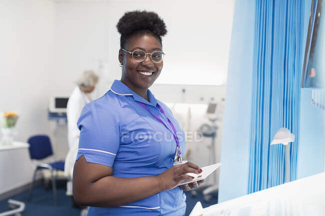 Porträt selbstbewusste Krankenschwester mit digitalem Tablet im Krankenhauszimmer — Stockfoto