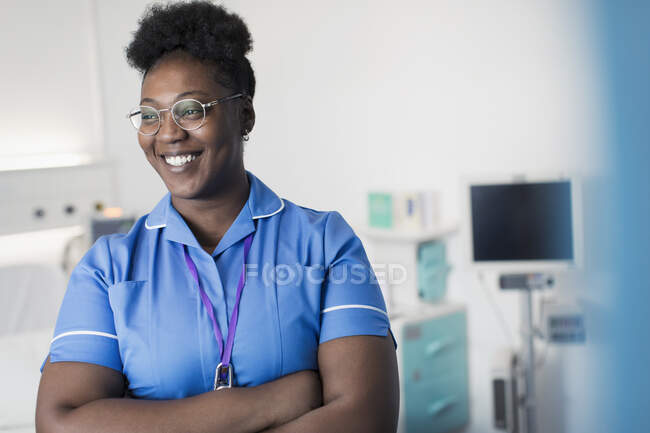 Retrato confiado, enfermera sonriente en la habitación del hospital - foto de stock