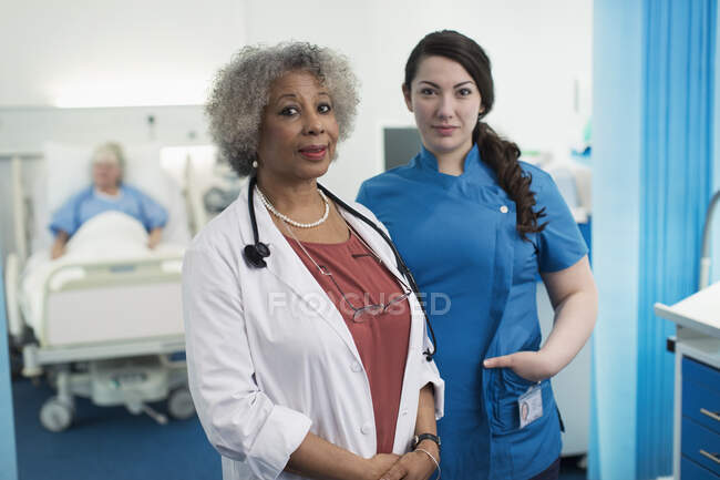 Retrato confiado médico y enfermera en la habitación del hospital - foto de stock