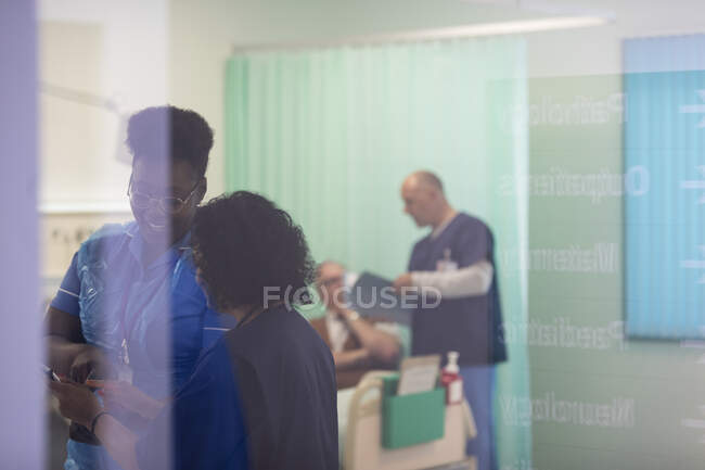 Female doctor and nurse talking in hospital room — Stock Photo