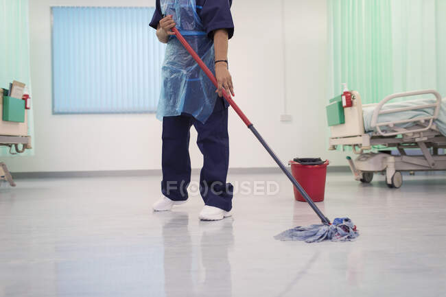 Female orderly mopping hospital ward floor — Stock Photo