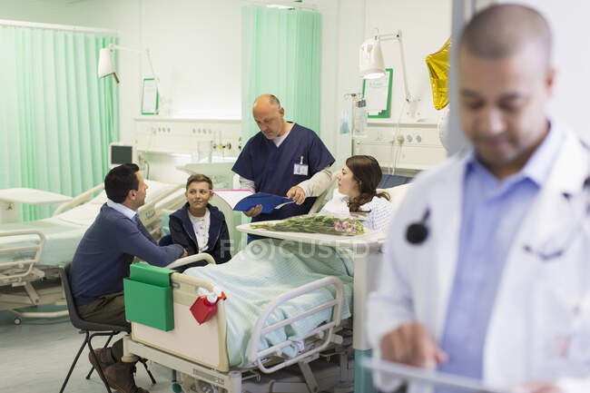 Arzt macht Runde, spricht mit Patient und Familie auf Krankenhausstation — Stockfoto