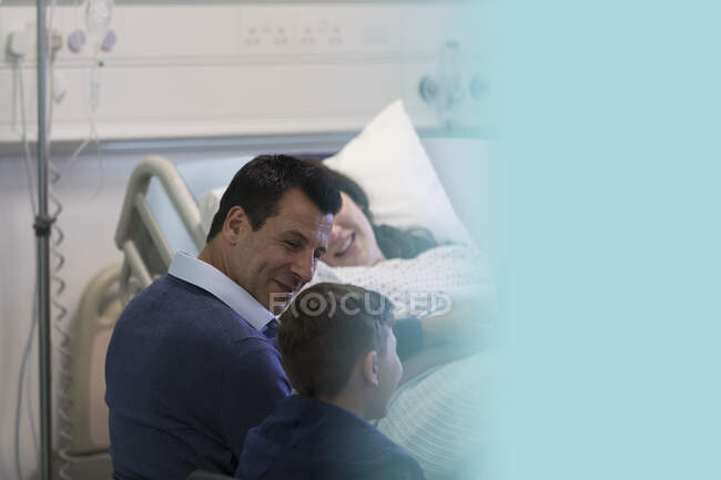 Familia visitando al paciente en la habitación del hospital - foto de stock