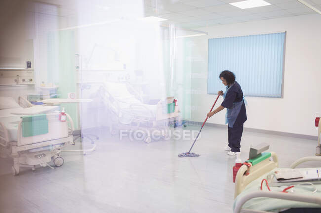 Жінка впорядковано обмотує підлогу лікарні — стокове фото