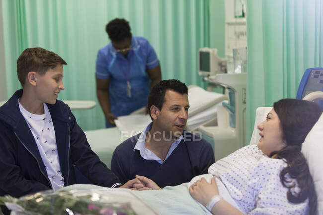 Family visiting, talking with patient in hospital ward — Stock Photo