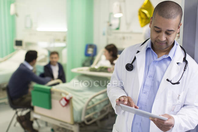 Врач-мужчина с цифровыми планшетами в палате больницы — стоковое фото