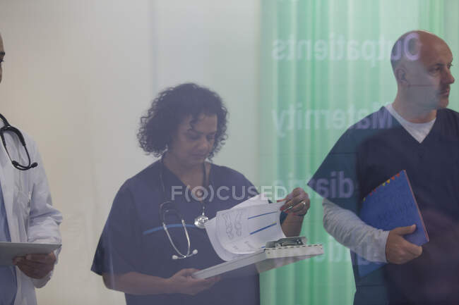 Médica revendo prontuário médico no hospital — Fotografia de Stock