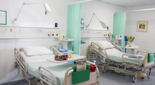 Flowers on trays over hospital beds in vacant hospital ward — Stock Photo