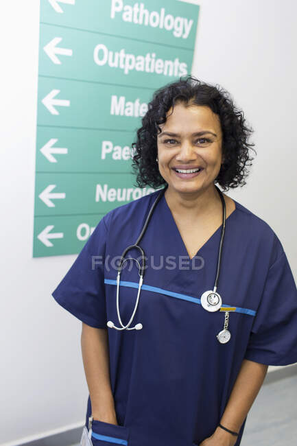 Портрет упевнений, щаслива жінка-лікар у лікарняному коридорі — стокове фото