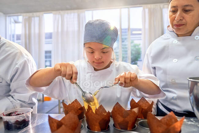 Jeune femme avec le syndrome de Down en cours de cuisson — Photo de stock