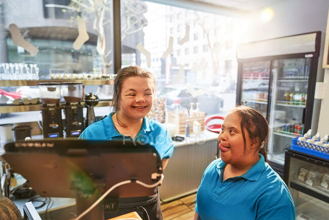 Happy young women with Down Syndrome working in cafe — Stock Photo