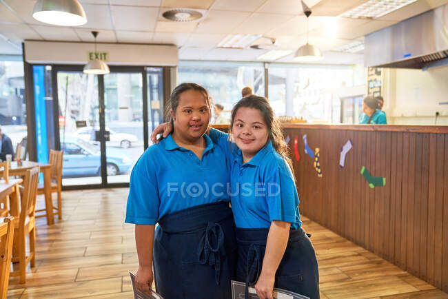 Portrait confident young women with Down Syndrome working in cafe — Stock Photo