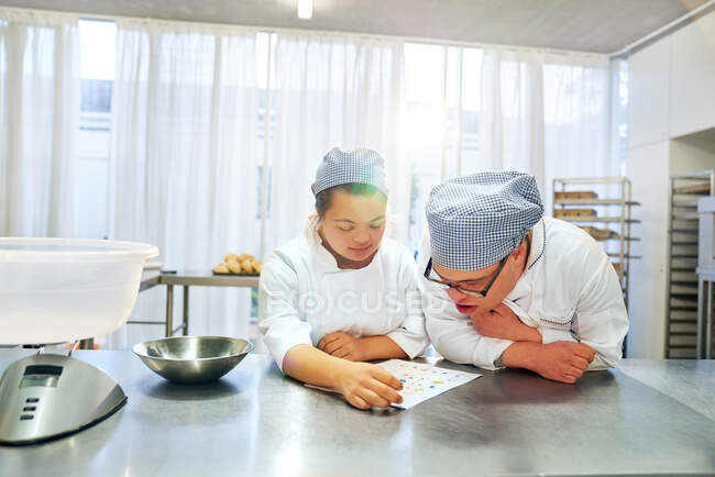 Students with Down Syndrome learning to bake in kitchen — Stock Photo
