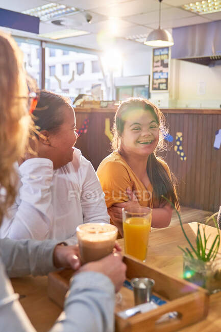 Mujeres jóvenes felices con síndrome de Down en la cafetería - foto de stock