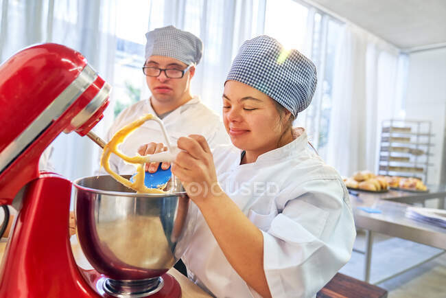 Young students with Down Syndrome using stand mixer in baking class — Stock Photo
