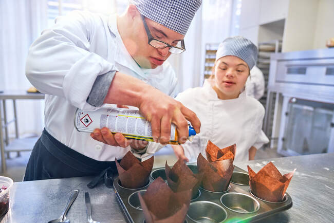 Étudiants atteints du syndrome de Down cuisson muffins dans la cuisine — Photo de stock