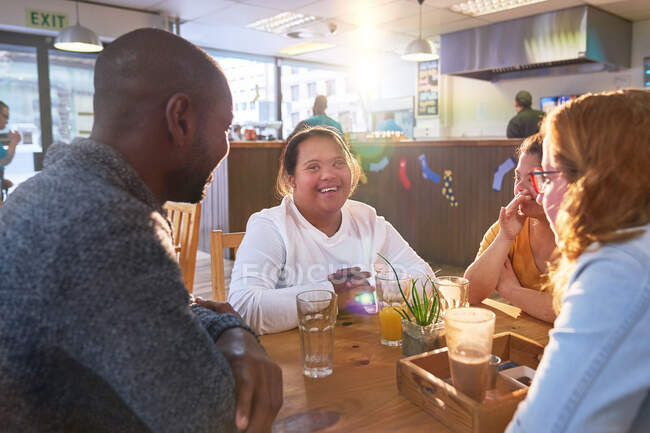 Щасливі молоді жінки з синдромом Дауна в кафе з друзями — стокове фото