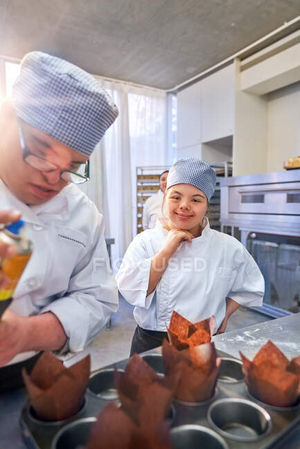 Joyeux jeune femme avec le syndrome de Down en cours de cuisson — Photo de stock