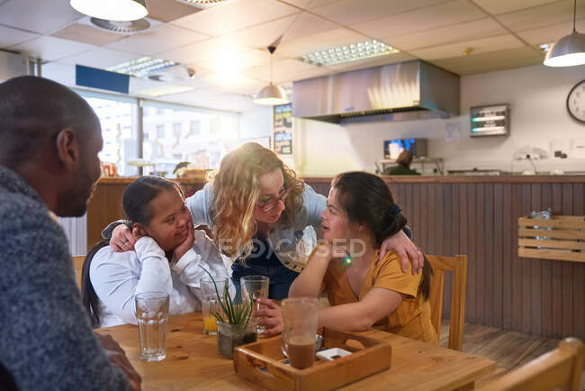 Мбаппе и молодые женщины с синдромом Дауна разговаривают в кафе — стоковое фото