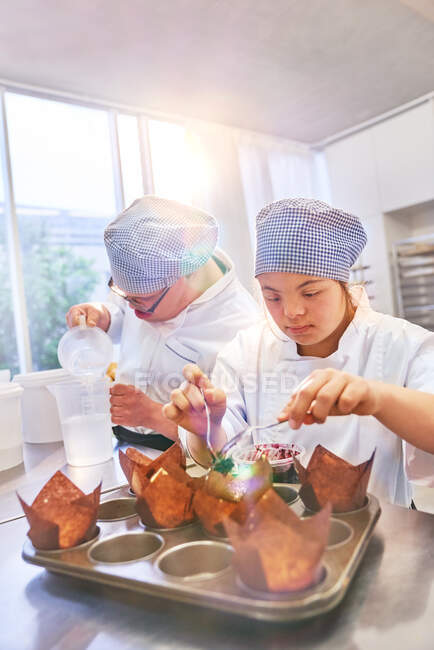 Young students with Down Syndrome baking muffins in kitchen — Stock Photo