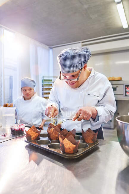 Focused young male student with Down Syndrome in baking class — Stock Photo