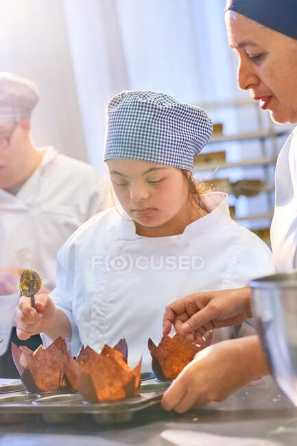 Chef e studente con muffin di cottura della sindrome di Down — Foto stock