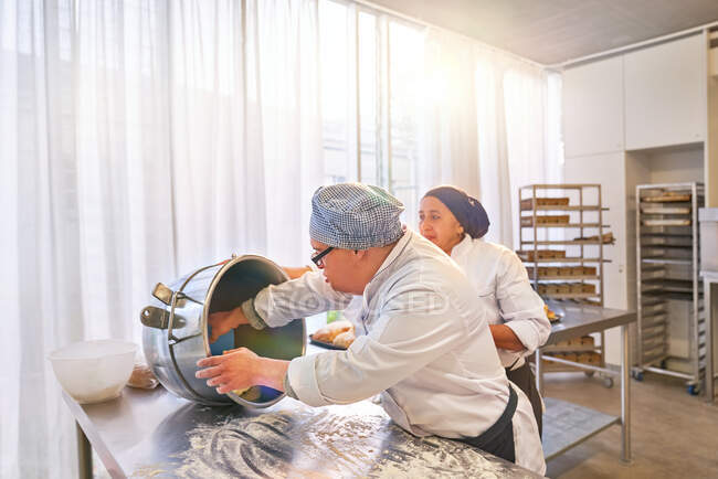 Chef and student with Down Syndrome baking in kitchen — Stock Photo