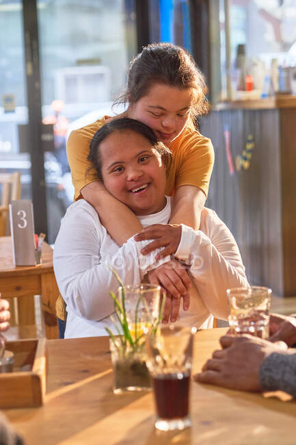 Portrait happy affectionate young women with Down Syndrome in cafe — Stock Photo