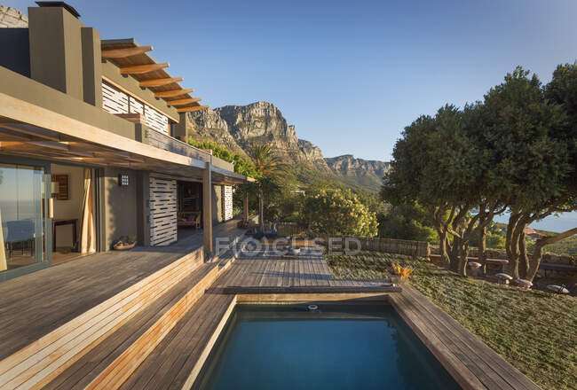 Mountains in background of luxury home showcase exterior house with swimming pool — Stock Photo