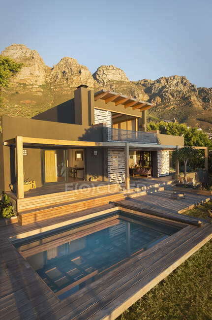 Montagnes derrière une maison de luxe ensoleillée Maison extérieure avec piscine — Photo de stock