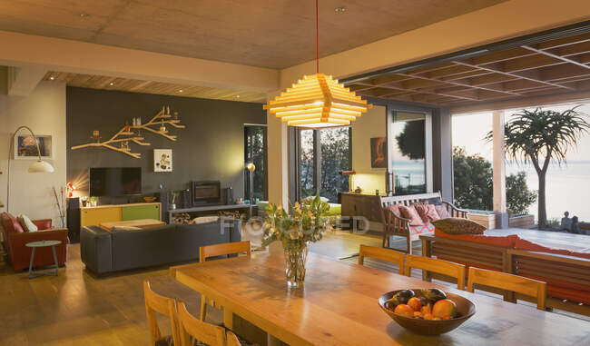 Illuminata moderna, casa di lusso vetrina sala da pranzo interna aperta sul patio — Foto stock