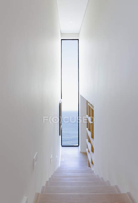Stairwell facing long window with ocean view in modern, luxury home showcase interior — Stock Photo