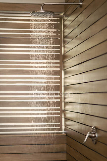 Acqua che cade dalla doccia a pioggia sotto la doccia in legno — Foto stock