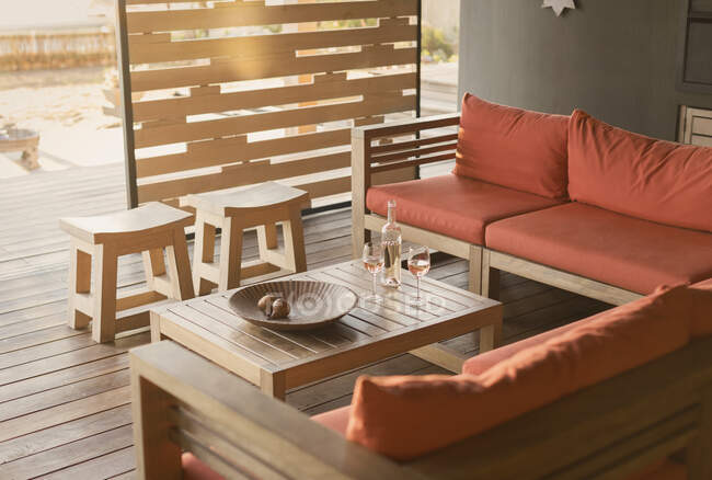 Vin de rose et canapé sur patio en bois, moderne et luxueux. — Photo de stock