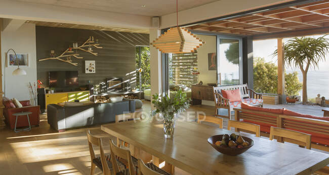Sunny modern, luxury home showcase interior dining room open to patio — Stock Photo