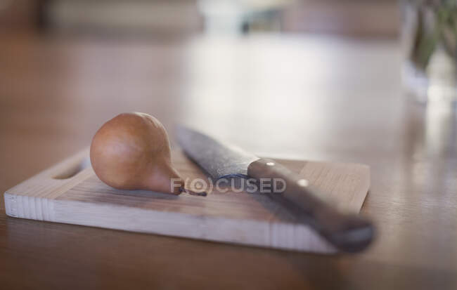 Натюрморт ножем і грушею на дерев'яній обробній дошці — стокове фото