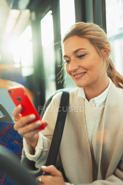 Молода жінка використовує смартфон у автобусі — стокове фото