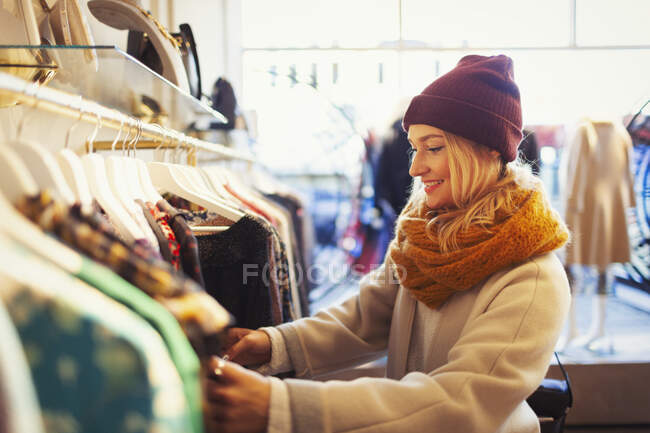 Mujer joven que compra ropa - foto de stock