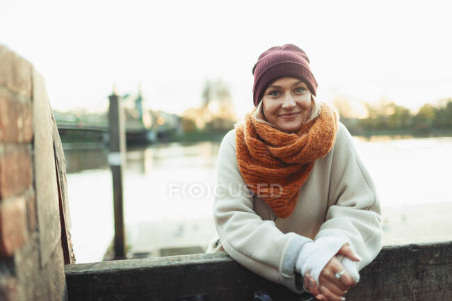 Portrait confident young woman in stocking cap and scarf — Stock Photo