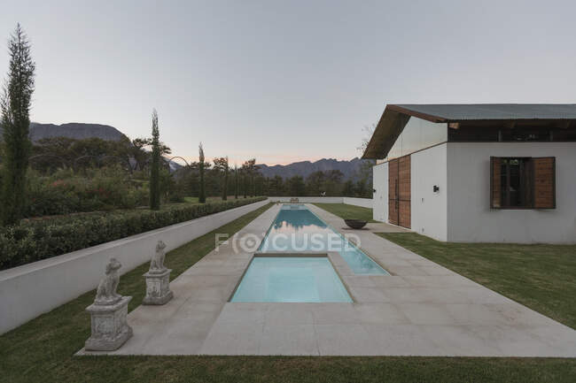Luxury lap pool and house at dusk — Stock Photo