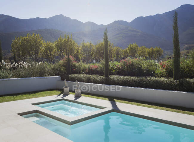 Sunny, idyllic lap pool and hot tub with tranquil mountain view — Stock Photo