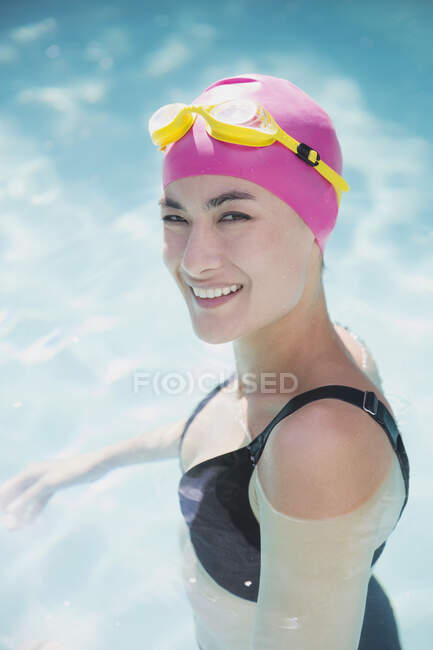 Porträt selbstbewusste Frau mit Badekappe und Schwimmbrille im Schwimmbad — Stockfoto