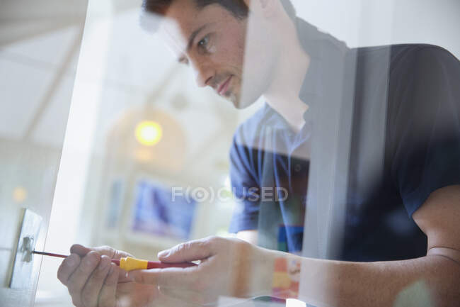 Electrician changing light fixture with screwdriver — Stock Photo