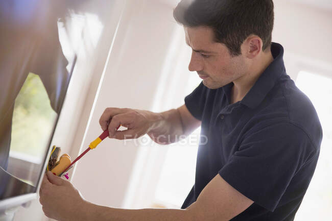 Electrician changing light fixture with tool — Stock Photo