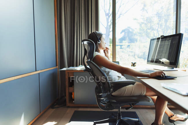 Бизнесмен, работающая за столом в солнечном офисе — стоковое фото