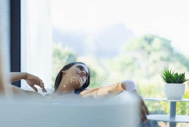 Serena mulher relaxante na banheira de imersão — Fotografia de Stock