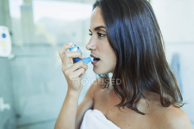 Jeune femme asthmatique utilisant un inhalateur — Photo de stock
