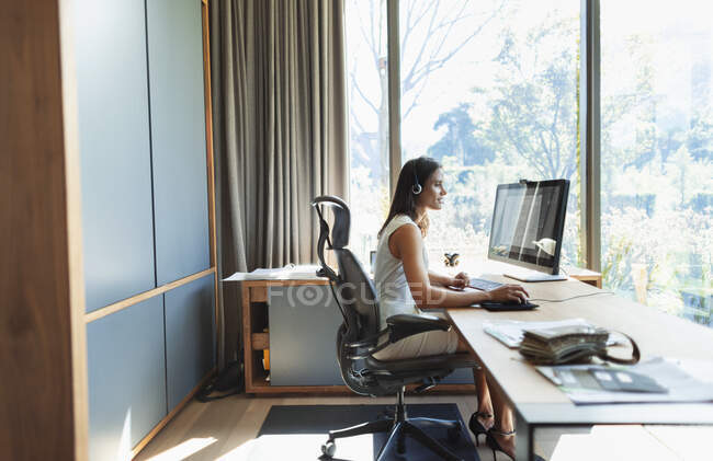 Бизнесвумен, работающая за компьютером в домашнем офисе — стоковое фото