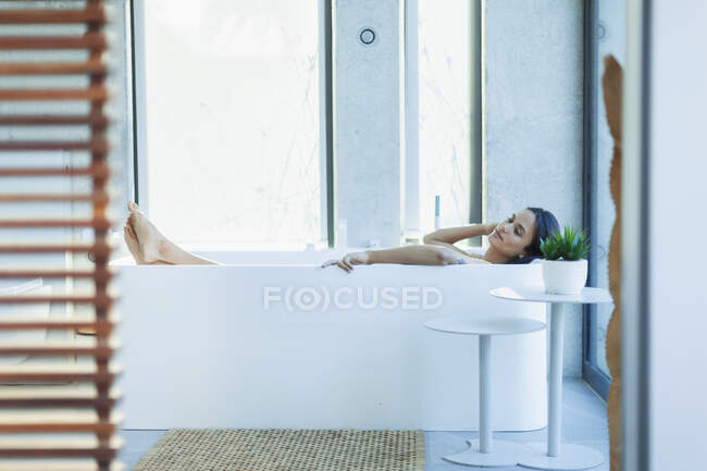 Serena mulher relaxante na moderna banheira de imersão — Fotografia de Stock