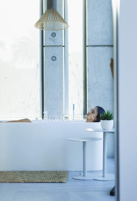 Serena mulher relaxante na banheira de imersão no banheiro moderno — Fotografia de Stock